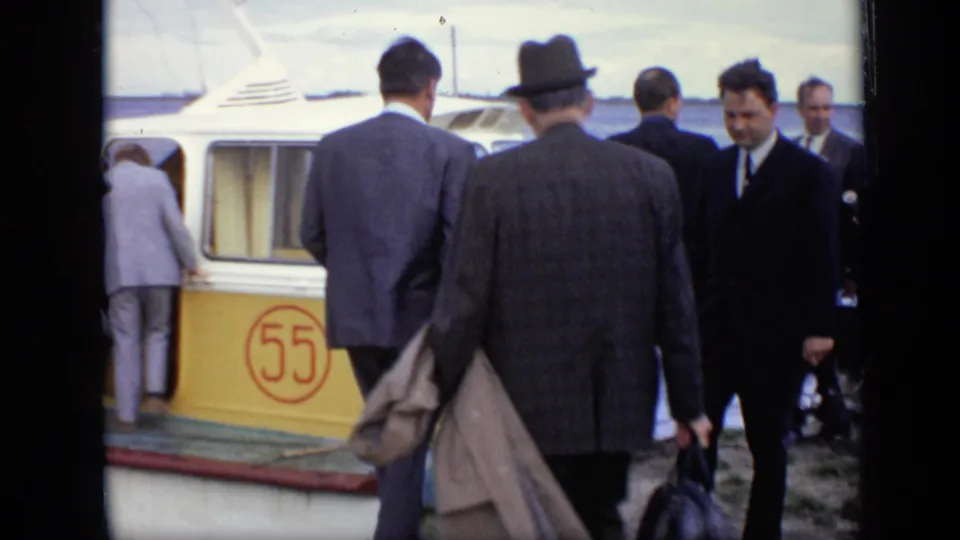 Suited men step toward and into a yellow-and-white passenger boat in Moscow, with the red number 55 visible on the side.