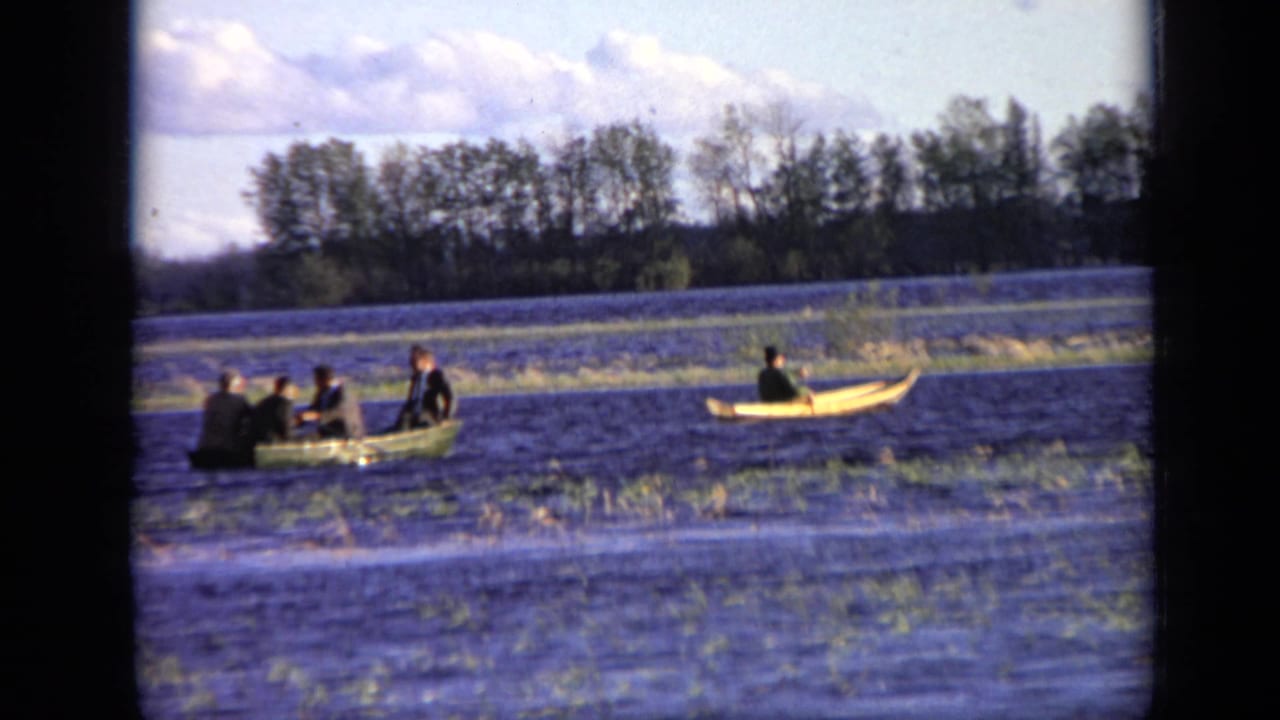 1971 Moscow river scene with a green rowboat carrying several men and a separate yellow canoe moving across calm water.