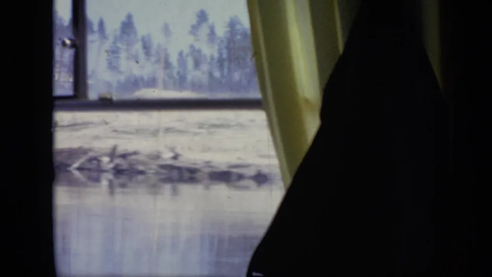 1971 Moscow travel footage frame with a silhouetted passenger near a yellow curtain and a soft riverside view outside.