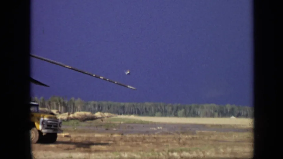 End frame from 1971 8mm footage near Moscow showing part of a yellow truck beside a broad field and distant trees.