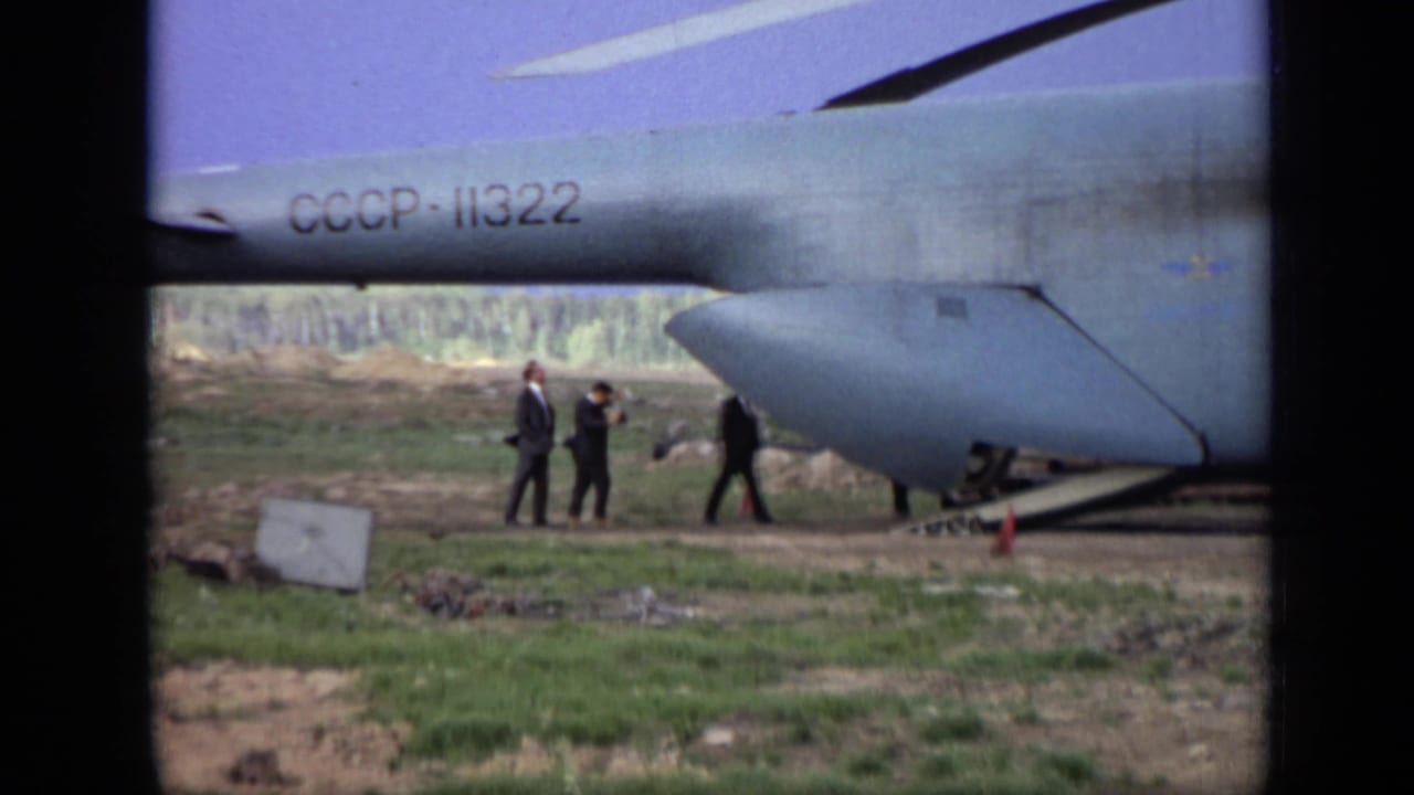 1971 Moscow 8mm footage showing a large Soviet aircraft marked CCCP-11322 while suited figures walk beside the fuselage.