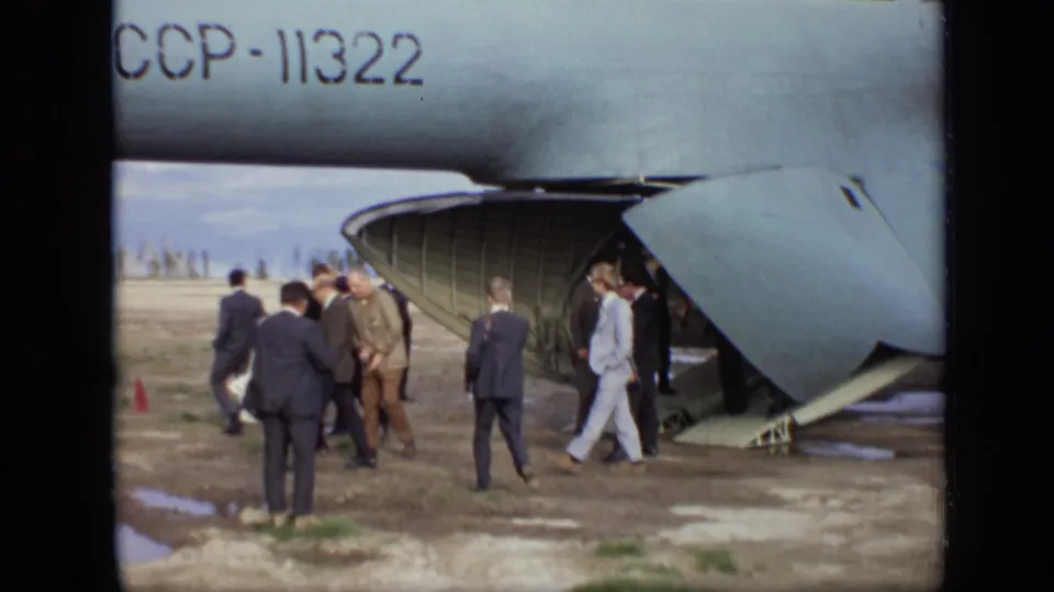 1971 Moscow footage shows civilian and military figures moving beside the open rear ramp of a large Soviet aircraft.