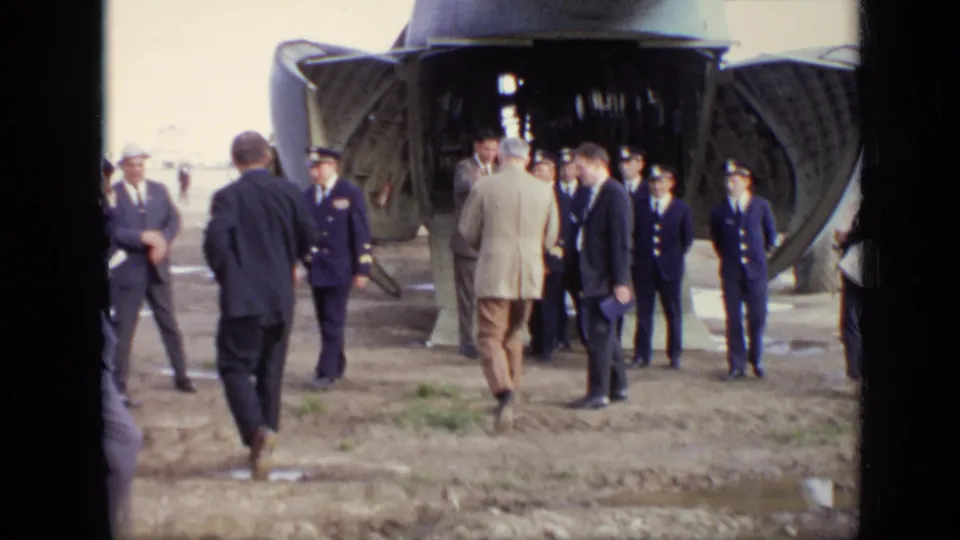 Closer 1971 Moscow airfield view of uniformed crew and suited officials beside the open rear of a Soviet transport aircraft.