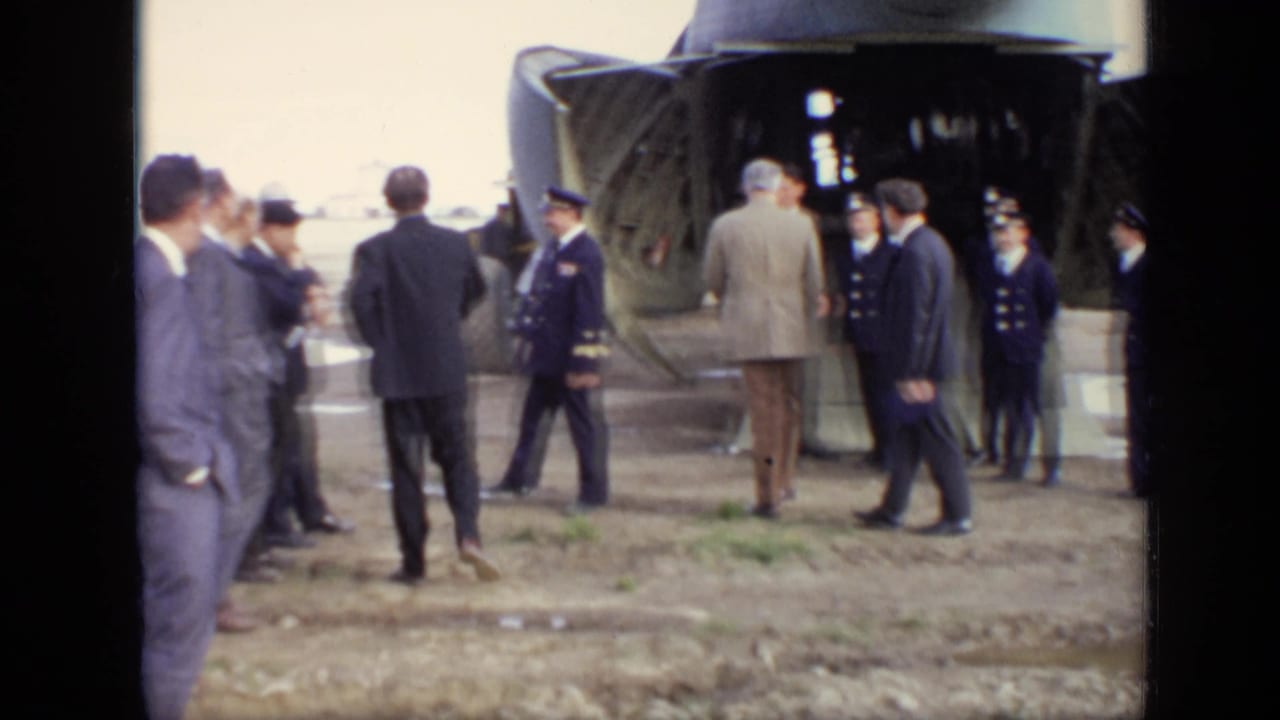 In Moscow in 1971, suited men and uniformed officers gather beside the open cargo ramp of a large military transport aircraft.