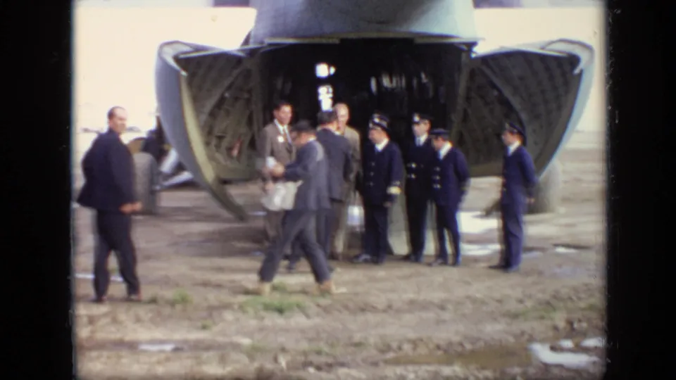1971 Moscow airfield footage shows men in suits and uniforms near the open rear ramp of a green cargo aircraft.