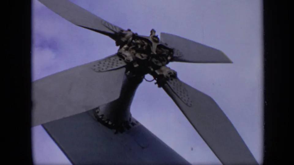 Close-up from the 1971 airfield footage shows the aircraft propeller hub and blades framed against a pale sky.