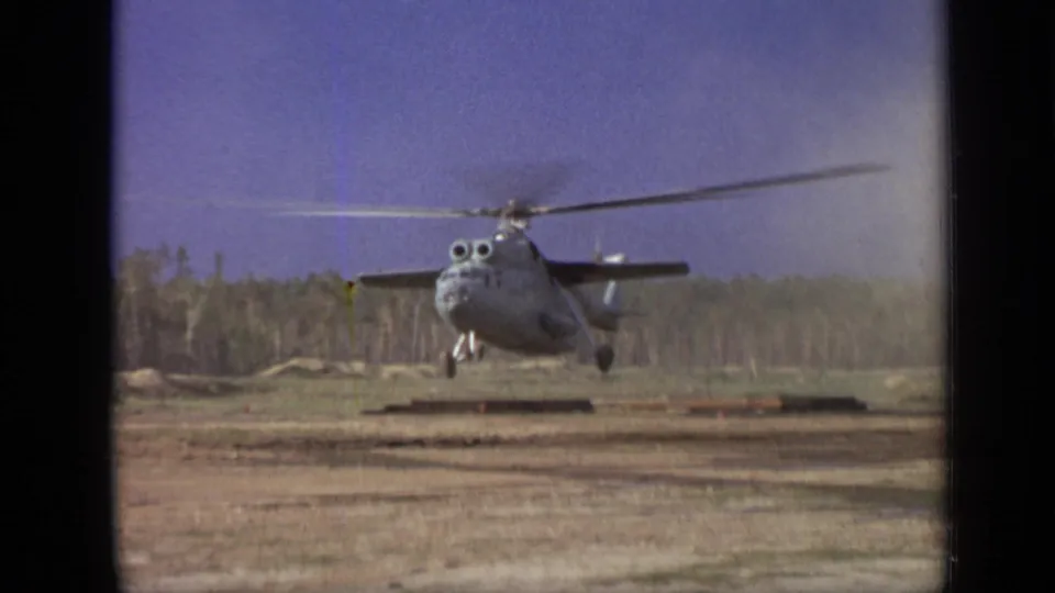 1971 Moscow metadata-supported frame showing a helicopter in low hover over a dusty field bordered by trees.