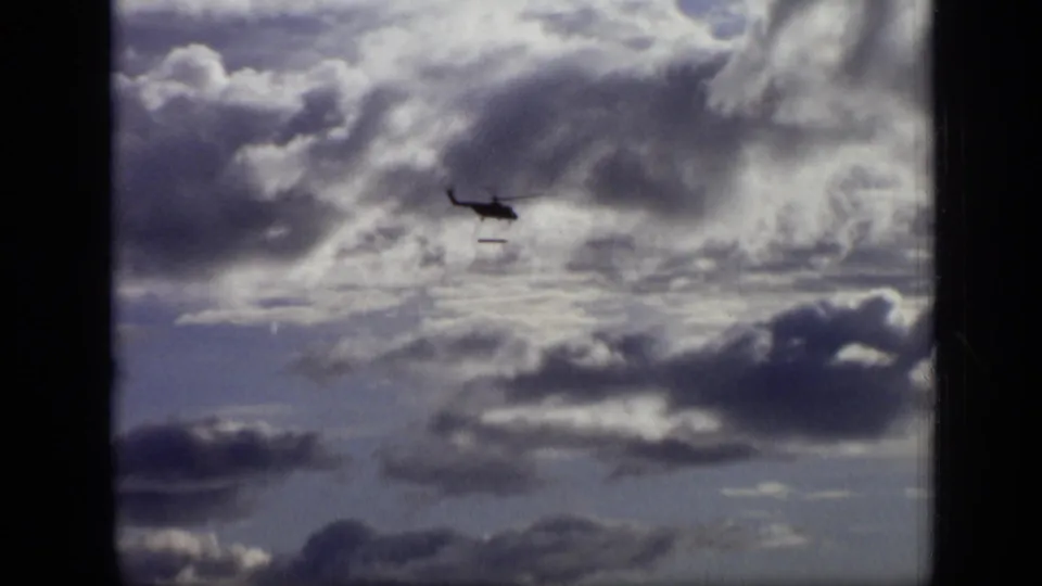 At the end of the 1971 Moscow clip, the helicopter is distant under heavy clouds with the long object still visible below.
