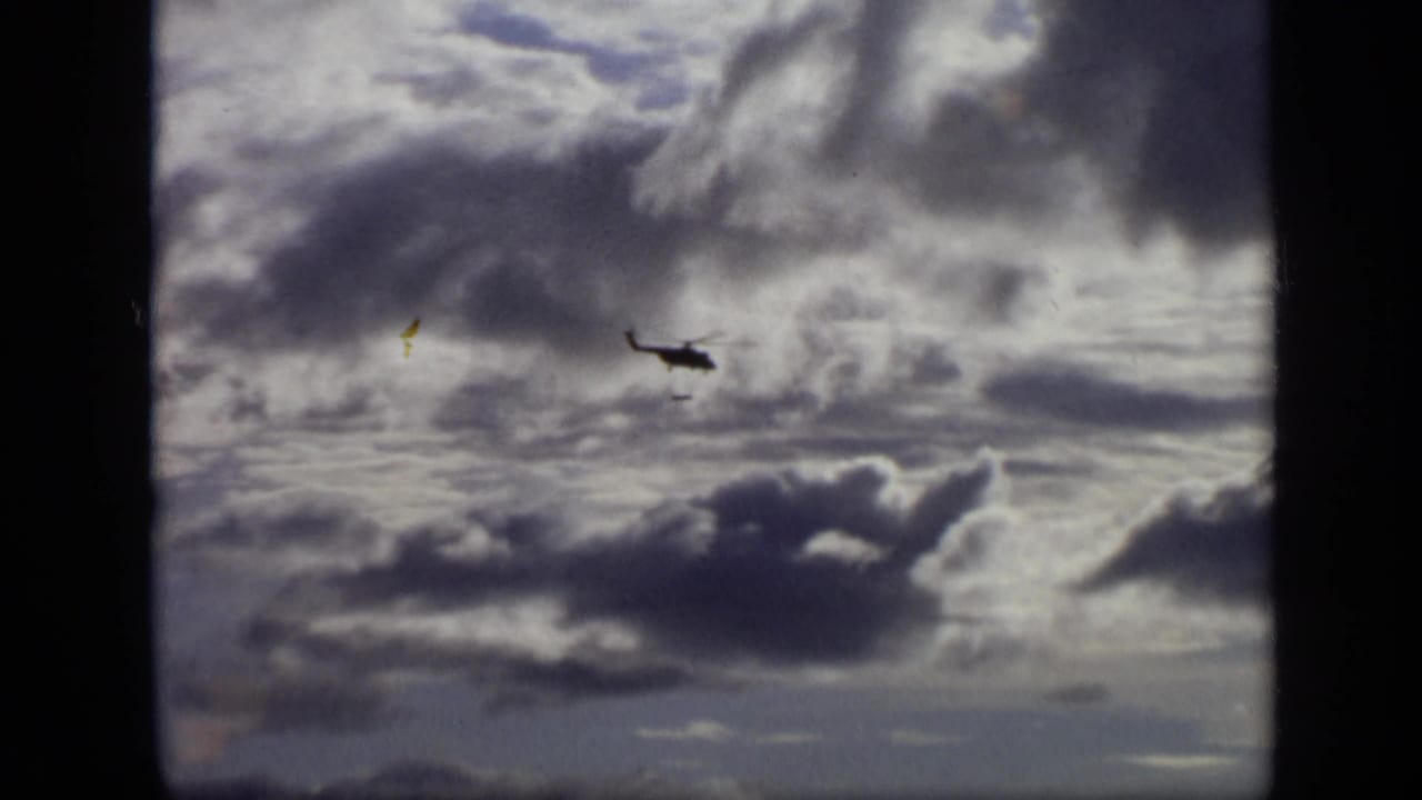 1971 Moscow 8mm frame with a helicopter moving through a dramatic cloud-filled sky.