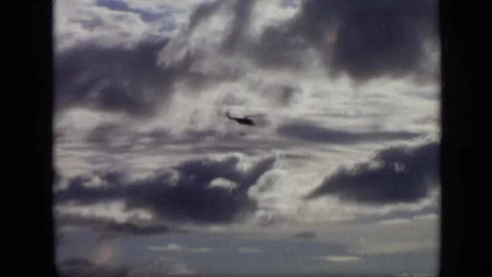 1971 Moscow home-movie frame showing the aircraft smaller and lower beneath heavy cloud cover.