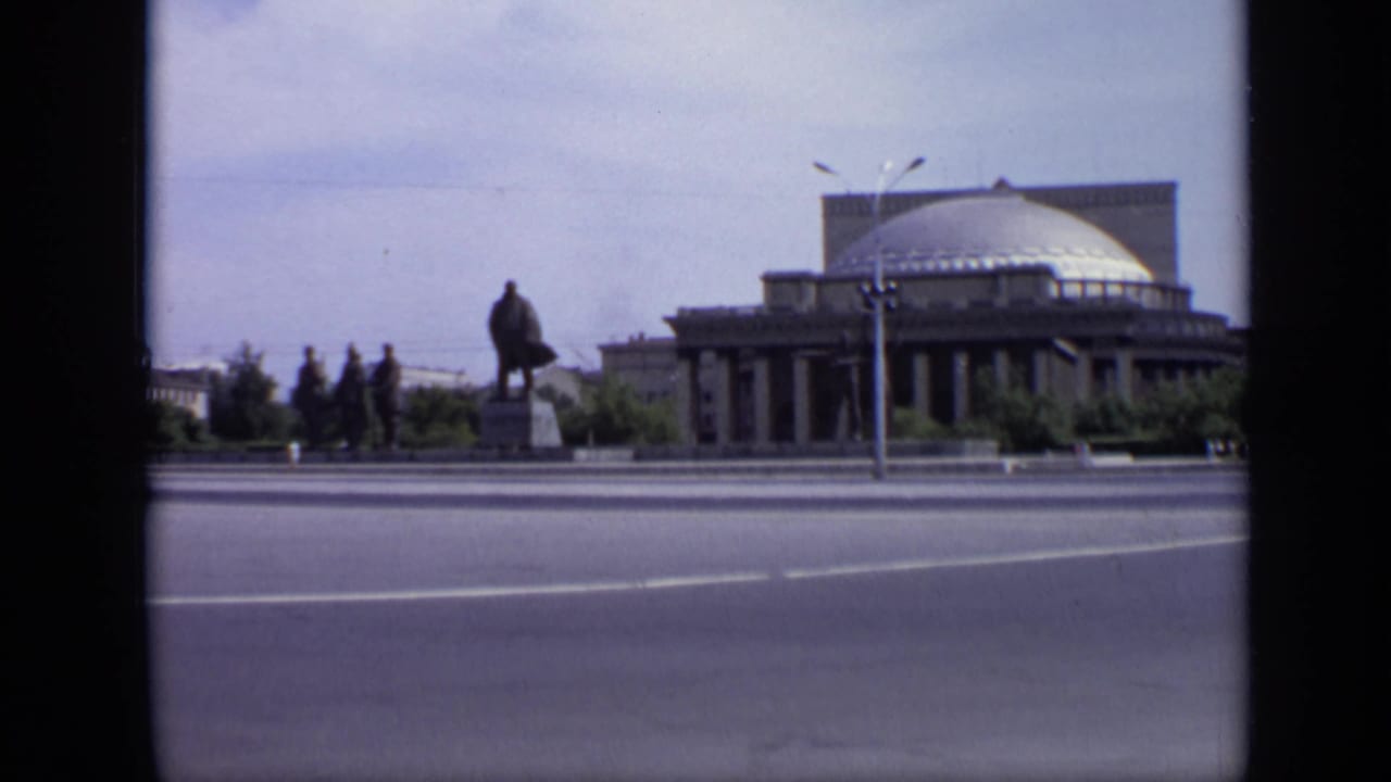 Wide Moscow street with domed building, statue, road, trees, and distant pedestrians.