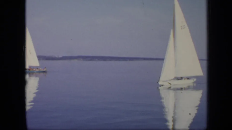 1971 Moscow sailing frame with two small boats on reflective water and a low shoreline in the distance.