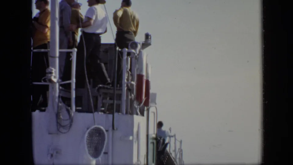 Adults on an upper boat deck stand near white railings during the supplied 1971 Moscow travel footage.