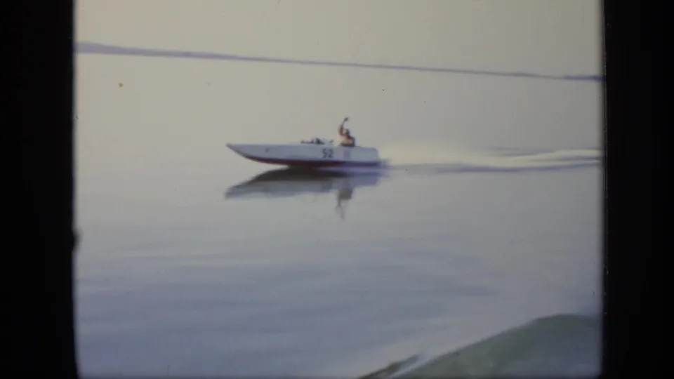 A white speedboat marked 52 travels across a calm Moscow river surface in the 1971 8mm footage.
