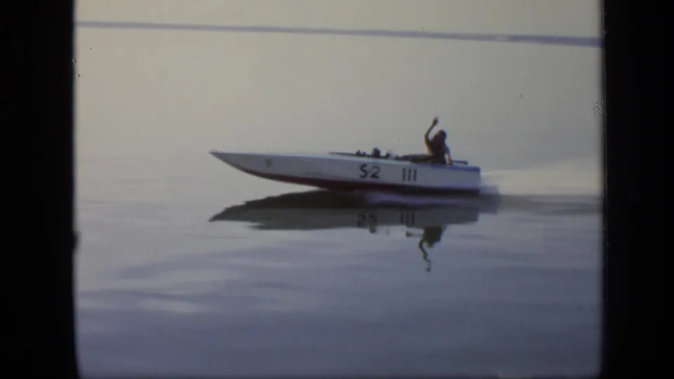 The white speedboat marked 52 III passes close enough to show the driver raising an arm on the Moscow river.