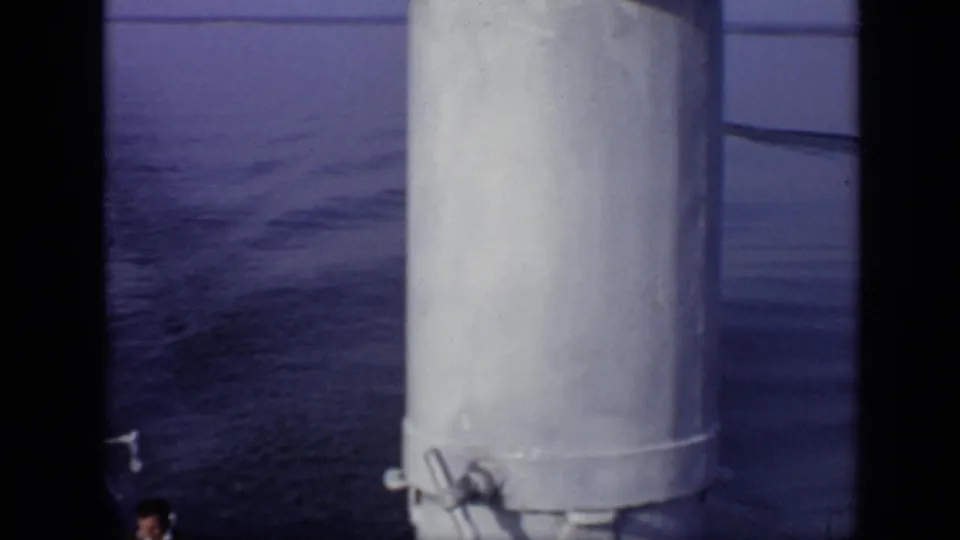 1971 8mm frame from Moscow, Russia showing a boat deck view with white structures, open water, and partial passengers at the edges.