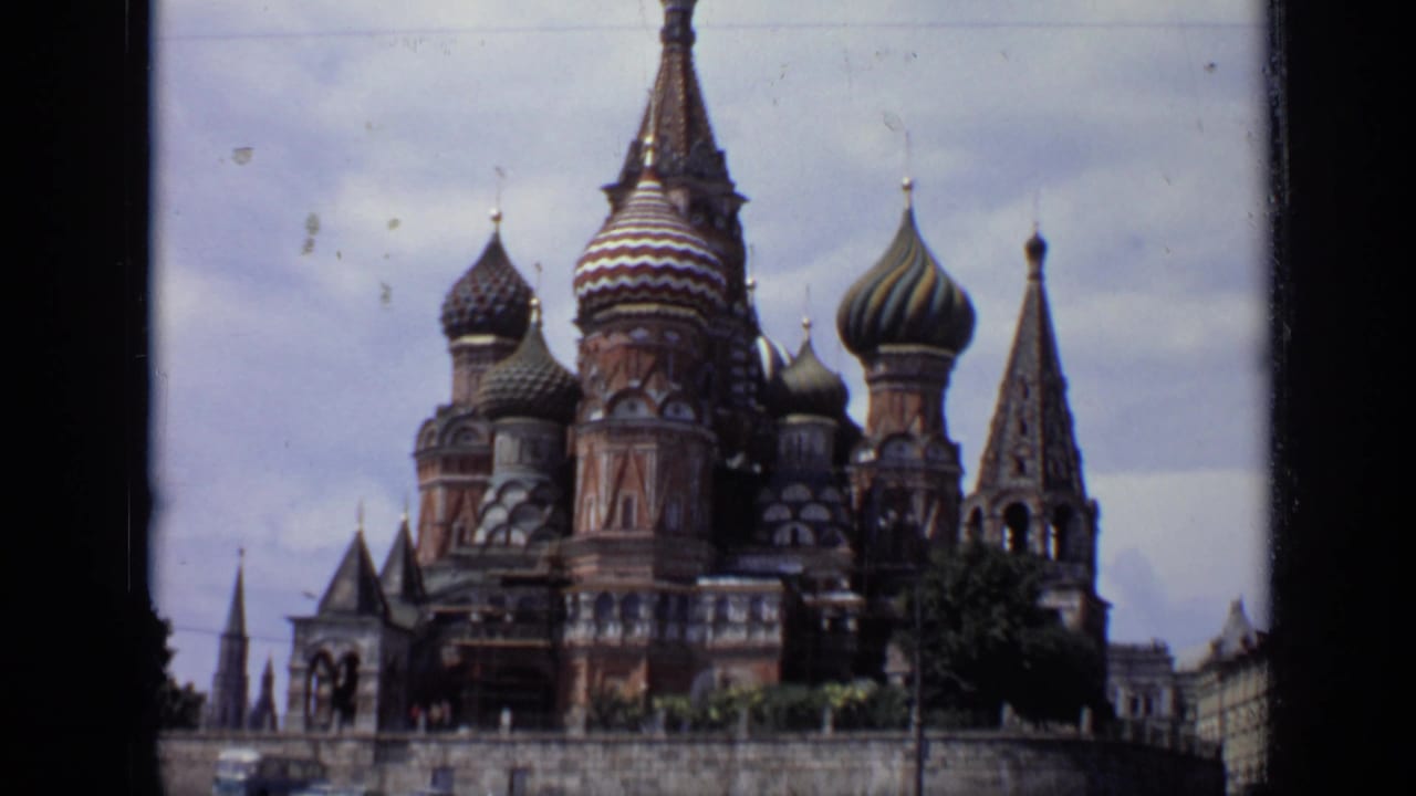 1971 8mm view of St. Basil's Cathedral in Moscow, showing patterned onion domes, brickwork, and spires beneath cloudy sky.