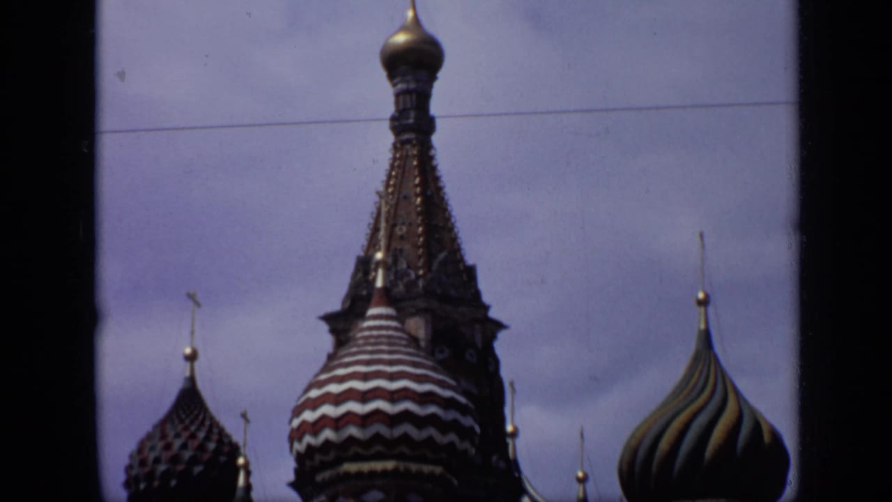 St. Basil's Cathedral onion domes seen against a pale sky with dark 8mm frame borders.
