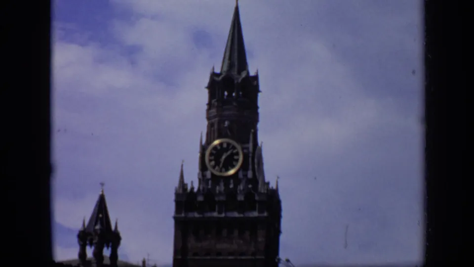 1971 Moscow 8mm close shot of Spasskaya Tower, emphasizing the clock face and tall spire against a cloudy sky.