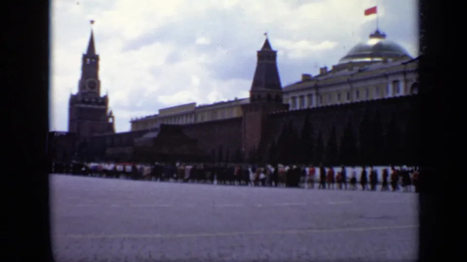 1971 Moscow home-movie frame showing the Kremlin wall, Spasskaya Tower, crowds, and a domed building edge near Red Square.