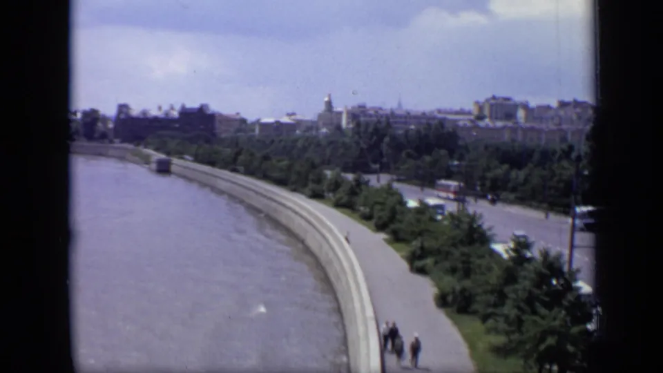 A wider 1971 Moscow panorama shows the riverfront embankment, tree belt, boulevard traffic, pedestrians, and distant urban skyline.