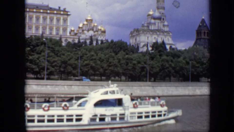 Moscow 1971 8mm still showing a white river passenger boat below Kremlin domes, towers, trees, and the embankment wall.