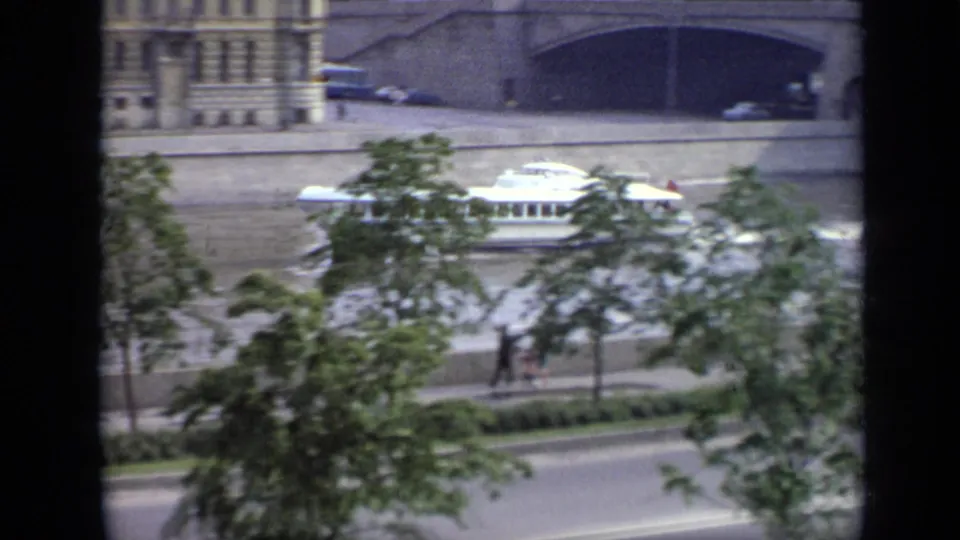 1971 Moscow 8mm frame showing a white riverboat on a wide river, partly obscured by trees and dark foreground framing.