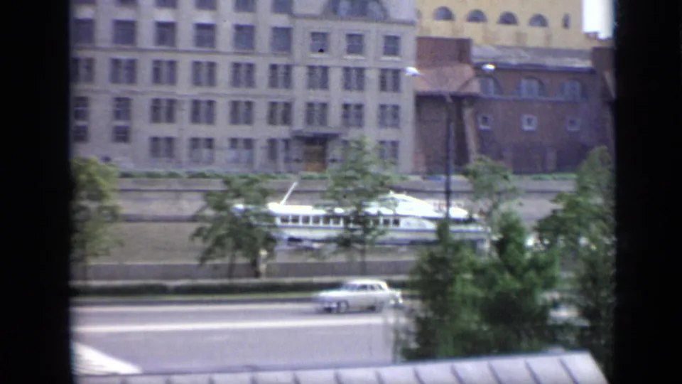1971 Moscow 8mm frame with a white boat near the embankment and a boxy white car on the foreground road.