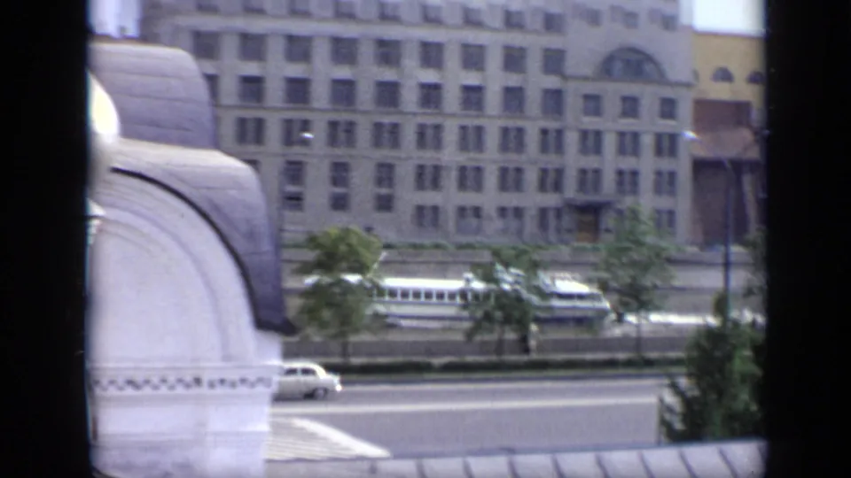 1971 Moscow riverside view with ornate white domes in the foreground, a road, trees, and large buildings beyond the water.