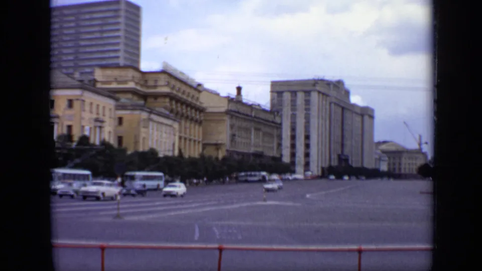 1971 Moscow street scene showing buses and cars on a broad square beside monumental architecture and a distant construction crane.