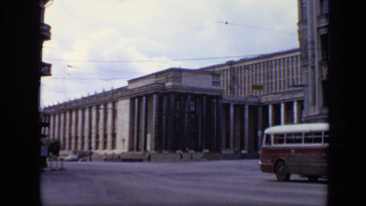 1971 Moscow view of a wide street, overhead wires, a large columned building, and a red-and-white bus entering at right.