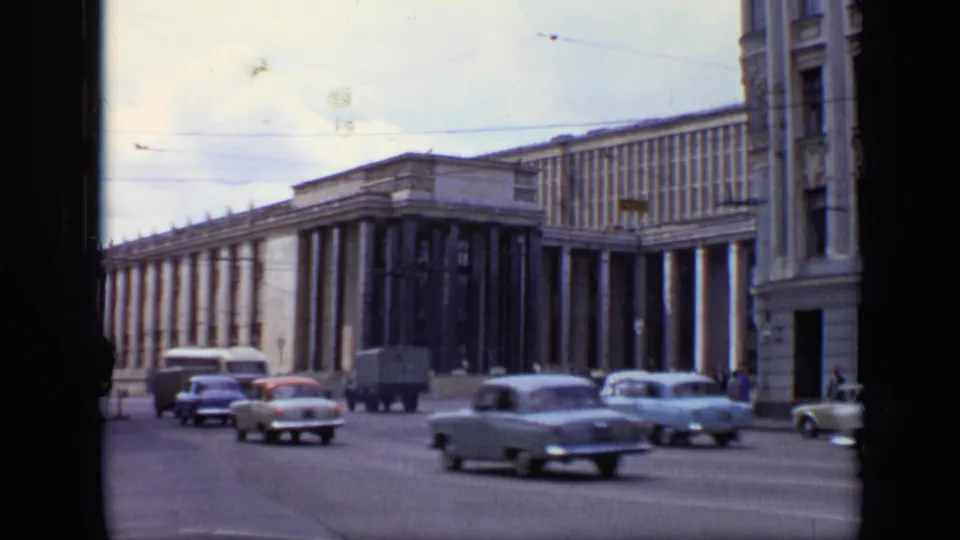 A busy 1971 Moscow street scene shows several cars, a small truck, pedestrians, and a large columned public building.