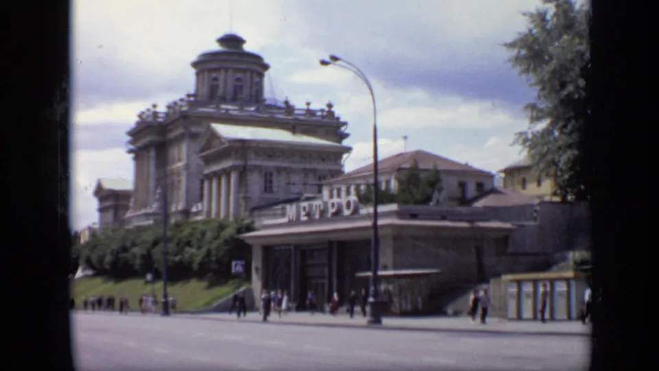 1971 Moscow street view showing a domed classical building, Metro signage, pedestrians, and a broad road under cloudy skies.