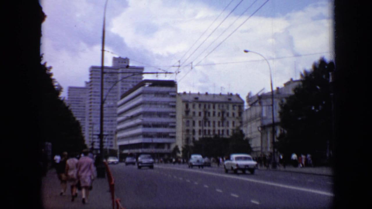 1971 Moscow street view from an elevated or roadside vantage, showing pedestrians, cars, mid-century buildings, trees, and overhead wires.