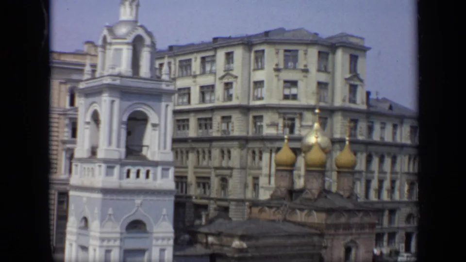 1971 Moscow rooftop view with golden onion domes, a white bell tower, and large apartment buildings behind them.