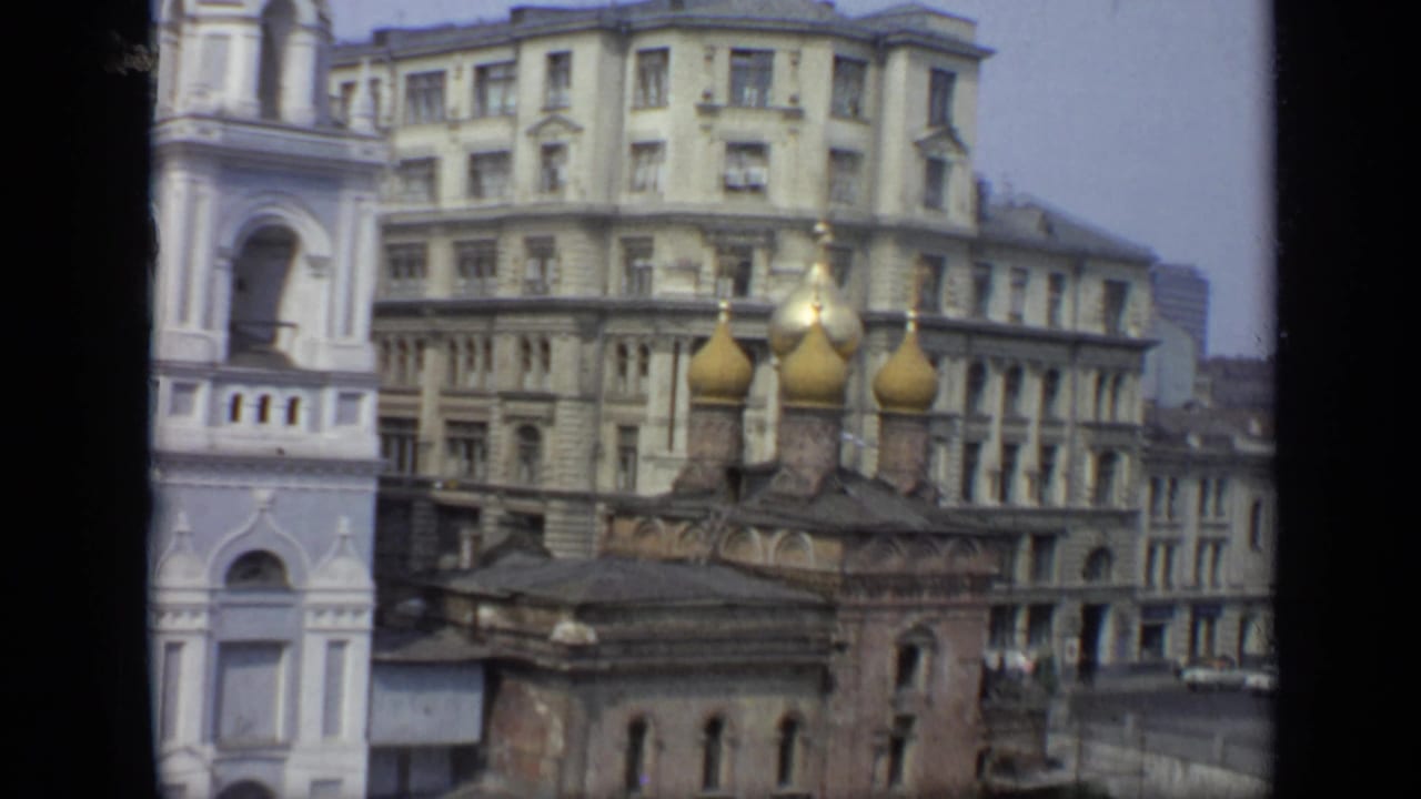 Church domes and bell tower framed with a large apartment block behind.