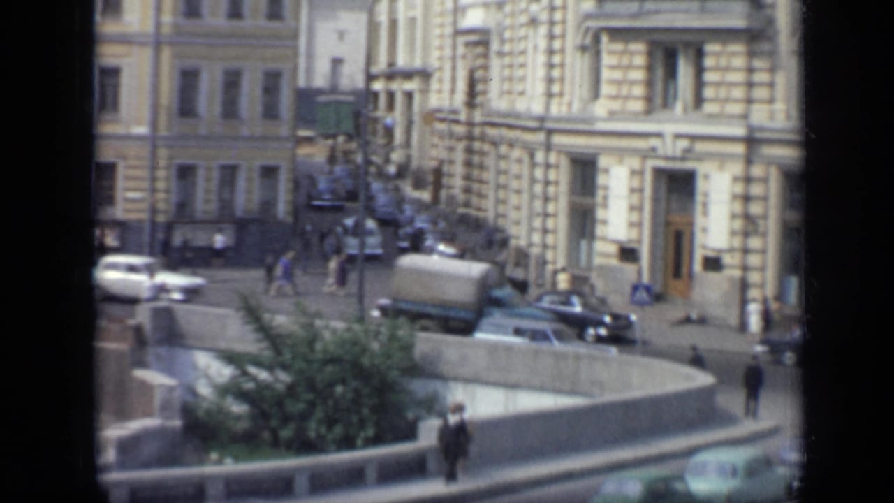 1971 Moscow downtown view with a truck, sedans, pedestrians, a sidewalk, and a concrete island with greenery.