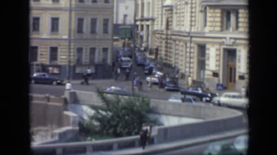 1971 Moscow street traffic with pedestrians crossing near classic cars, sidewalks, and multi-story stone buildings.
