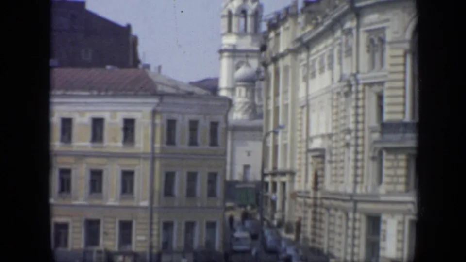 1971 Moscow view of ornate facades and a church tower with onion domes above a street with cars and pedestrians.