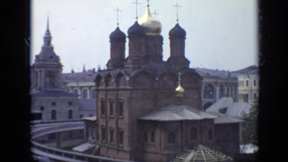 1971 Moscow 8mm frame showing historic church architecture with onion domes, crosses, and adjacent spires viewed from an elevated angle.