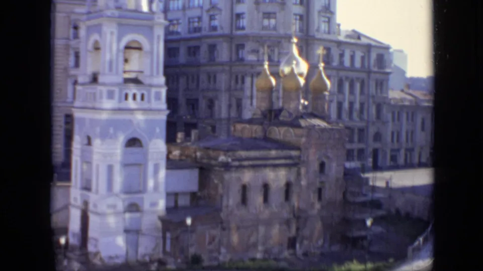 1971 Moscow street view with a white bell tower, golden onion domes, and older residential buildings seen from above.