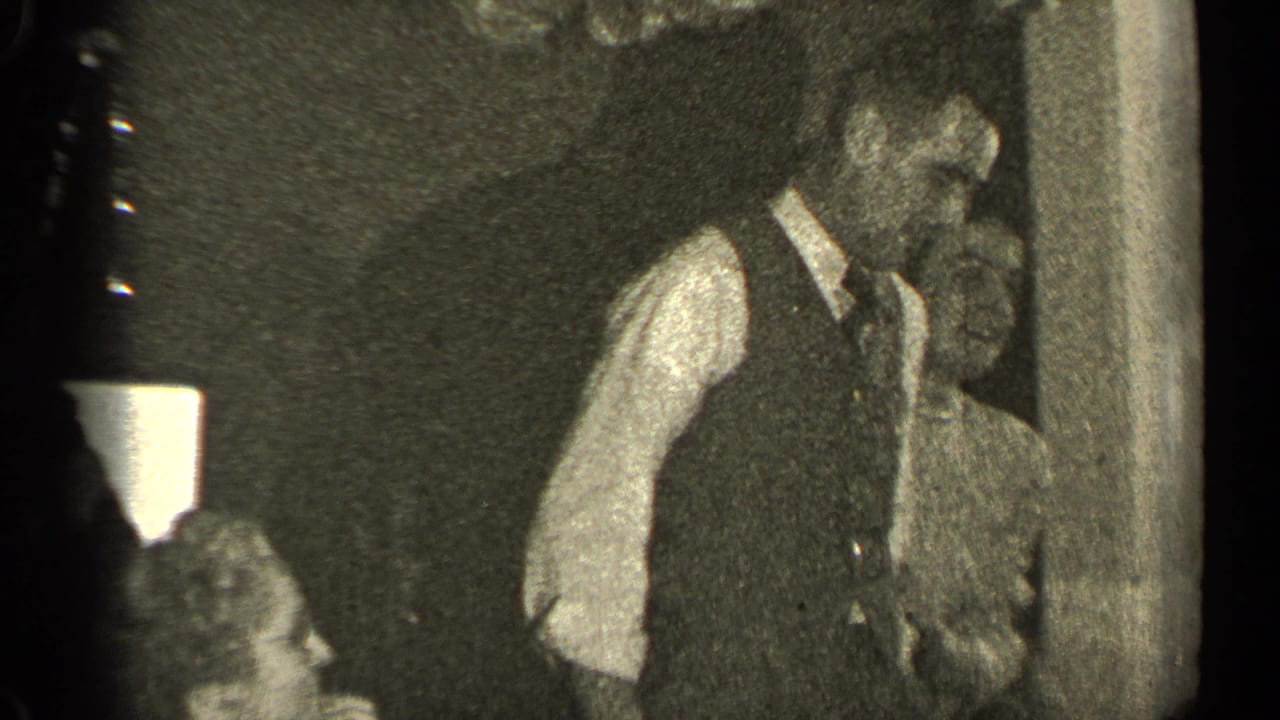 Man in vest dances beside a woman near seated guests.
