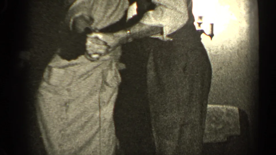 The woman appears to laugh or lean toward her partner while dancing in grainy 1947 Illinois home-movie footage.