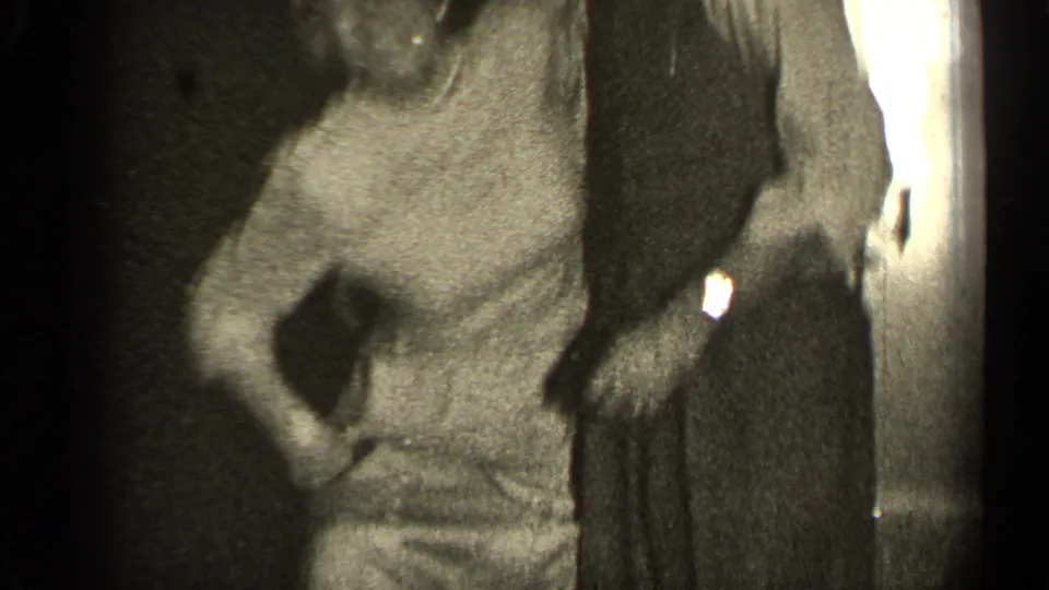 A woman in a light dress turns toward the camera as her dance partner remains partly cropped.