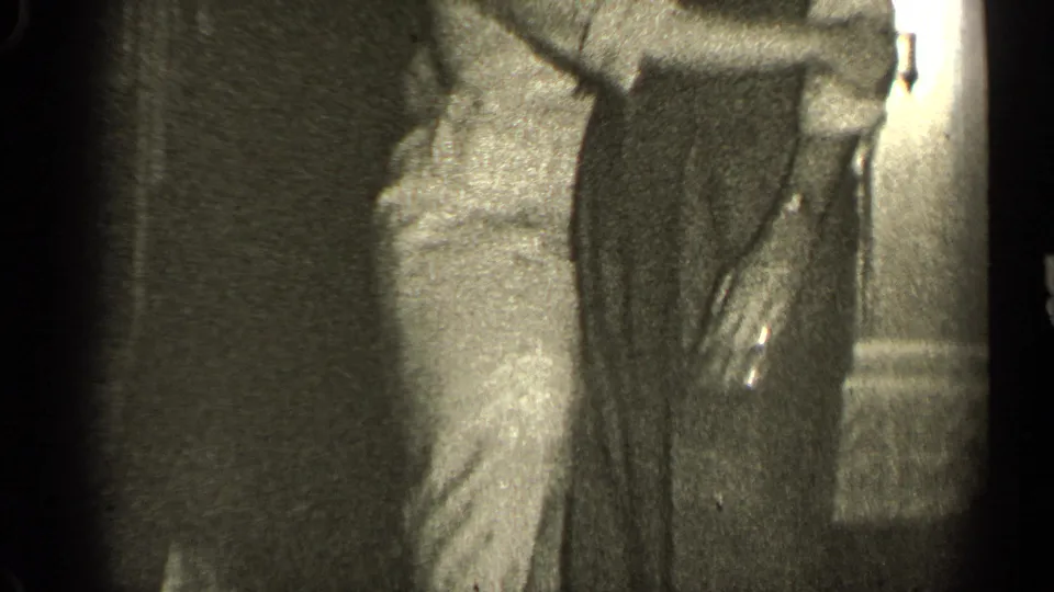 A cropped 1947 Illinois home-movie frame shows the dancers' torsos and hands as they continue moving together.