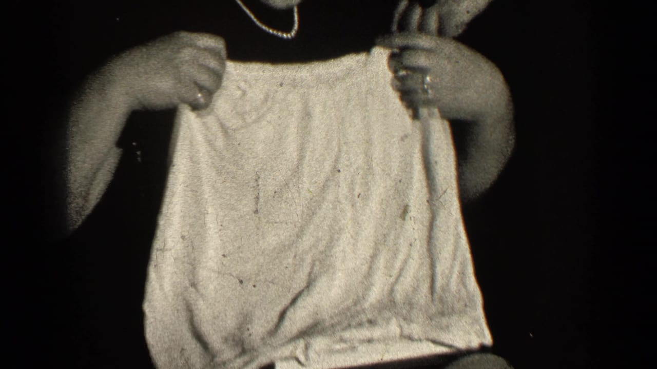 A light garment is stretched open by hands in close view.
