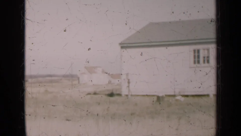 End frame shows part of a white rural building with windows beside an open Illinois field.