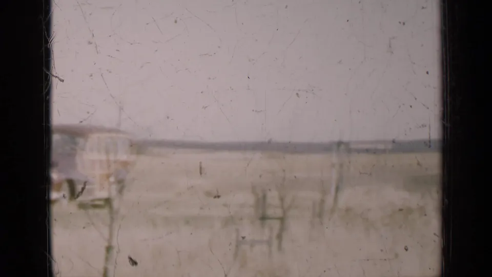 End frame from the 1947 Illinois 8mm shot, with the car partly cropped and flat rural land in view.