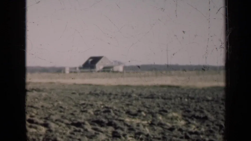 1947 Illinois rural view with rough foreground field, a distant building, and visible 8mm surface wear.