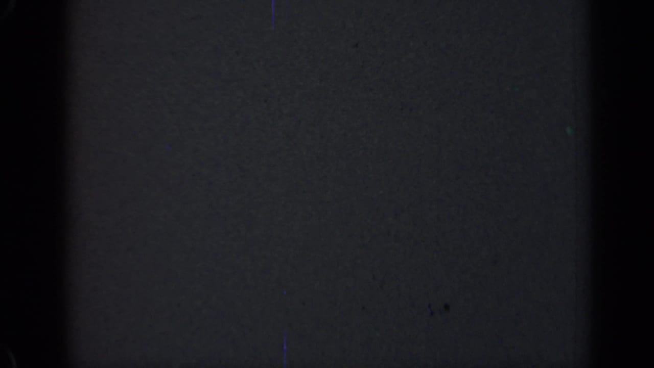 Dark 1947 Illinois 8mm frame with a broad black vertical band, faint surface scratches, dust specks, and uneven film density.